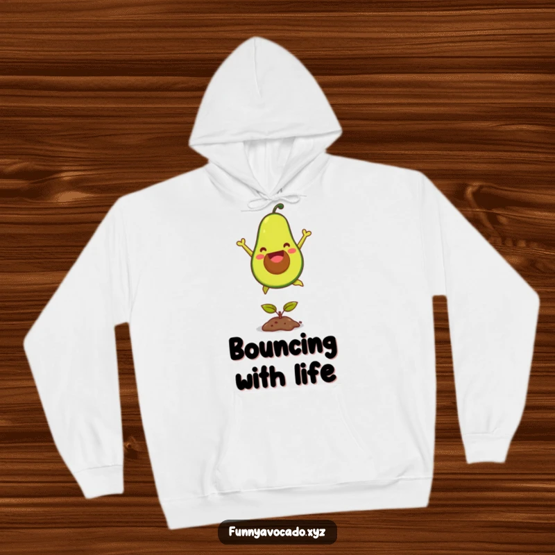 Funny joyful avocado hoodie, depicted mid-leap over a seedling, offering warmth and humorous charm for casual wear.